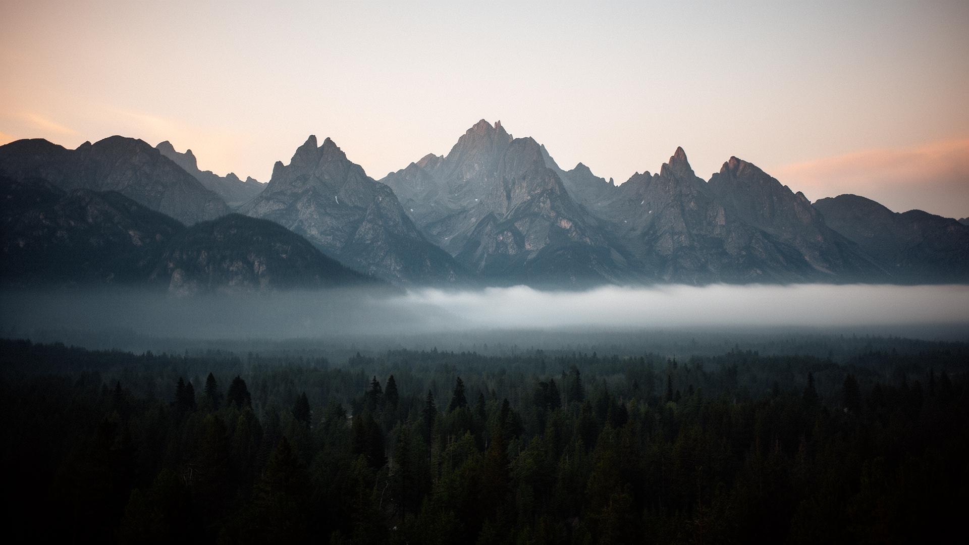 Misty mountain ridges above a forested valley at dawn